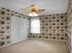Bedroom featuring a fan and light fixture, floral wallpaper, carpet, and closet with folding doors at 702 Minus St, Saint George, SC 29477