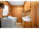 Functional laundry room with washer, dryer, ample storage, and wood-paneled walls at 702 Minus St, Saint George, SC 29477