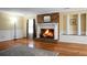 Cozy living room with a brick fireplace, hardwood floors, and wainscoting, creating a warm and inviting atmosphere at 702 Minus St, Saint George, SC 29477