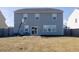 View of the home's back exterior, showcasing the sliding glass door, basketball hoop, and spacious yard at 705 Squire Pope Rd, Summerville, SC 29486
