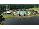 Aerial view of the large community pool area, surrounded by landscaping, a lake and ample seating at 705 Squire Pope Rd, Summerville, SC 29486