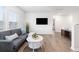 Bright living room featuring a gray sofa, white walls, wood floors, and large windows that let in plenty of natural light at 705 Squire Pope Rd, Summerville, SC 29486