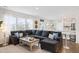 Inviting living room with a large sectional sofa, bright windows, and a view of the open-concept kitchen at 705 Squire Pope Rd, Summerville, SC 29486
