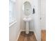 Small powder room with pedestal sink and an oval mirror at 705 Squire Pope Rd, Summerville, SC 29486