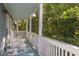 Inviting balcony with white rocking chairs surrounded by lush greenery at 73 Fairway Dunes Ln, Isle of Palms, SC 29451