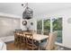 Elegant dining area with seating for eight, stylish lighting fixture, and sliding glass doors to the outside at 73 Fairway Dunes Ln, Isle of Palms, SC 29451