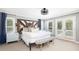 Spacious main bedroom with light gray paint, white linens, bench and double doors to balcony at 73 Fairway Dunes Ln, Isle of Palms, SC 29451