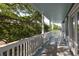 Relaxing covered porch with rocking chairs and view of a lush green space at 73 Fairway Dunes Ln, Isle of Palms, SC 29451