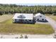 Aerial view of a modern farmhouse with white siding, metal roof, and a detached garage on a large lot at 733 Oakridge View Trl, Ridgeville, SC 29472