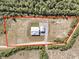 Aerial view of a modern farmhouse on expansive lot surrounded by trees with a red border highlighting the property lines at 733 Oakridge View Trl, Ridgeville, SC 29472