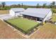 Aerial view of a modern farmhouse with large, fenced yard, screened-in patio, and outbuilding at 733 Oakridge View Trl, Ridgeville, SC 29472