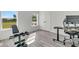 Minimalist bedroom with exercise equipment, desk, office chair, and two windows with natural light at 733 Oakridge View Trl, Ridgeville, SC 29472