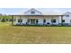 Modern farmhouse with large covered porch, white siding, metal roof, and well-manicured lawn and landscaping at 733 Oakridge View Trl, Ridgeville, SC 29472