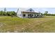 Beautiful modern farmhouse featuring white siding, metal roof, large front yard, and covered porch with wooden pillars at 733 Oakridge View Trl, Ridgeville, SC 29472