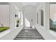 Bright hallway features a gray and white striped rug, windows, and a white front door at 733 Oakridge View Trl, Ridgeville, SC 29472