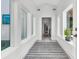Bright hallway features a gray and white striped rug, windows, and a view to the laundry room at 733 Oakridge View Trl, Ridgeville, SC 29472