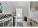 Spacious laundry room with gray cabinets, gray appliances, countertop, sink, and door to hallway at 733 Oakridge View Trl, Ridgeville, SC 29472