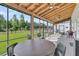Screened-in patio with wood ceiling, outdoor fan, round table, and view of a fenced yard at 733 Oakridge View Trl, Ridgeville, SC 29472