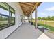 Inviting porch with wooden beams, large windows, and concrete floor; perfect for enjoying the outdoors at 733 Oakridge View Trl, Ridgeville, SC 29472
