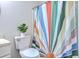 Close-up of bathroom with a patterned shower curtain, toilet, and a small houseplant at 7965 Edgebrook Cir # F, North Charleston, SC 29418
