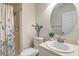 This bathroom features a modern shower, patterned shower curtain, and round mirror at 7965 Edgebrook Cir # F, North Charleston, SC 29418