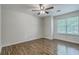 This well lit bedroom features wood-look floors, a ceiling fan, and a large window at 7965 Edgebrook Cir # F, North Charleston, SC 29418