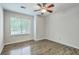 This well lit bedroom features wood-look floors, a ceiling fan, and a large window at 7965 Edgebrook Cir # F, North Charleston, SC 29418