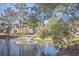 Scenic view of a pond with a fountain, lush trees, and community homes in the background at 7965 Edgebrook Cir # F, North Charleston, SC 29418