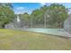 A fenced community tennis court surrounded by trees and lawn at 7965 Edgebrook Cir # F, North Charleston, SC 29418