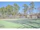 Community tennis court enclosed by a fence and surrounded by lush trees at 7965 Edgebrook Cir # F, North Charleston, SC 29418