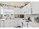 Traditional white kitchen with bright natural light, laminate counters, and white appliances at 801 Reserve Way, Summerville, SC 29485