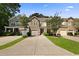 Attractive two-story townhomes featuring stone accents, covered entries, well-kept lawns, and attached garages and driveways at 849 Bibury Ct, Charleston, SC 29414
