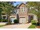 Attractive two-story townhome with a stone and siding facade, manicured landscaping, and convenient attached garage at 849 Bibury Ct, Charleston, SC 29414