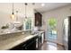 Modern kitchen with granite countertops, stainless steel appliances, and access to the backyard at 849 Bibury Ct, Charleston, SC 29414