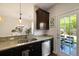 Well-lit kitchen with granite countertops, stainless steel appliances, and backyard access at 849 Bibury Ct, Charleston, SC 29414