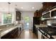 Well-lit kitchen with granite countertops, dark cabinets, and stainless steel appliances, plus backyard access at 849 Bibury Ct, Charleston, SC 29414