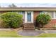 Charming brick home featuring a lovely blue door and manicured bushes and brick steps at 9995 Lodge Hwy, Lodge, SC 29082