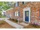 Inviting brick home showcasing a charming blue front door with decorative trim and a manicured garden bed at 103 Sylvan Ter, Summerville, SC 29485