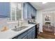 This kitchen showcases blue cabinets, a stainless steel sink, modern appliances, and abundant natural light at 103 Sylvan Ter, Summerville, SC 29485