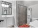 Bathroom features a white vanity, decorative mirror, and patterned shower curtain at 1069 Blockade Runner Pkwy, Summerville, SC 29485