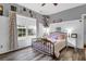A secondary bedroom with a black metal frame bed, wood floors, and a large window at 1069 Blockade Runner Pkwy, Summerville, SC 29485