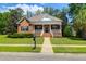 Charming brick home featuring a welcoming front porch, manicured lawn, and mature landscaping at 1069 Blockade Runner Pkwy, Summerville, SC 29485