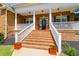Inviting front porch featuring brick stairs, white railings, columns, and decorative flower pots at 1069 Blockade Runner Pkwy, Summerville, SC 29485