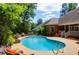 Backyard pool with outdoor seating, lush landscaping and a well-maintained patio for relaxing and entertaining at 1069 Blockade Runner Pkwy, Summerville, SC 29485