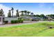 Elegant community entrance sign with brick columns, palm trees, flower beds, and meticulously maintained landscaping at 107 Pescaro Ln, Summerville, SC 29486