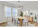 Bright dining room features a modern light fixture, wood table with seating for six, and lots of natural light at 107 Pescaro Ln, Summerville, SC 29486