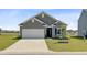 Charming single-story home with gray siding, a two-car garage, a well-kept lawn, and mature landscaping at 107 Pescaro Ln, Summerville, SC 29486