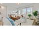 Comfortable living room features a leather sofa, bright chairs, and lots of natural light from the surrounding windows at 107 Pescaro Ln, Summerville, SC 29486