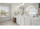 Bright bathroom featuring double vanity, white cabinets, modern fixtures, and a window for natural light at 1087 Clearspring Dr, Charleston, SC 29412