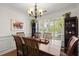 Elegant dining room with a large wooden table, decorative chandelier, and view of the outdoor scenery at 1087 Clearspring Dr, Charleston, SC 29412